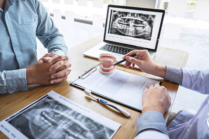 A dentist explaining dental implants to a patient.