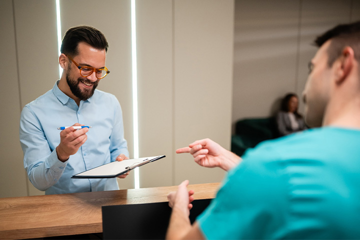 A man filling out forms on a clipboard.