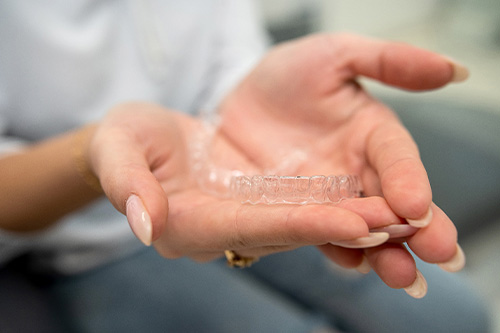 Closeup of patient holding clear aligner.