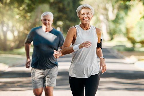 Couple smiling while running outside.