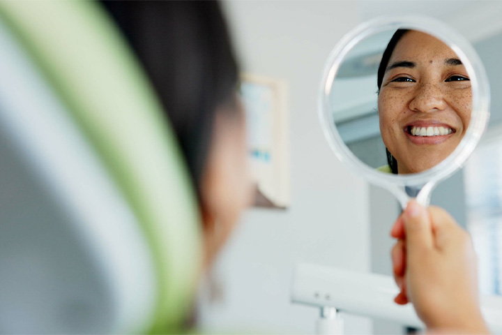 Patient smiling at reflection at mirro