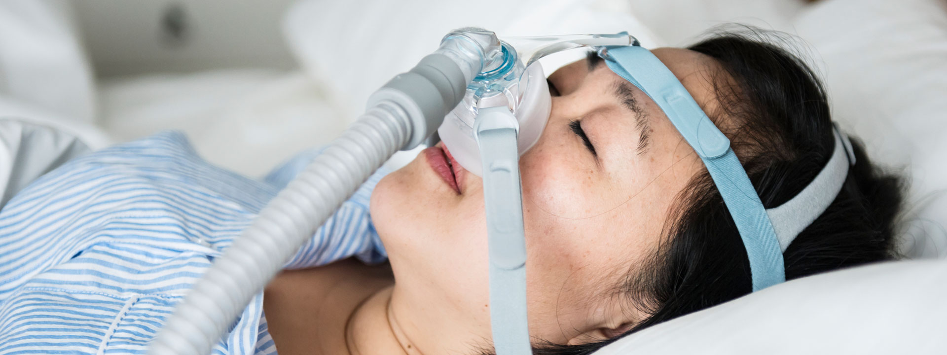 A woman is sleeping with anti-snoring machine